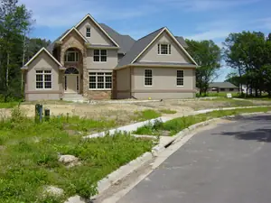 A new-construction house on a bare dirt lot, before landscaping