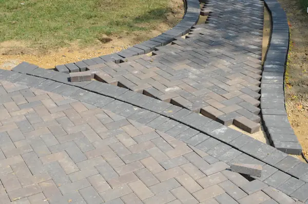 Brick paver walkway installation in progress, joints not yet filled
