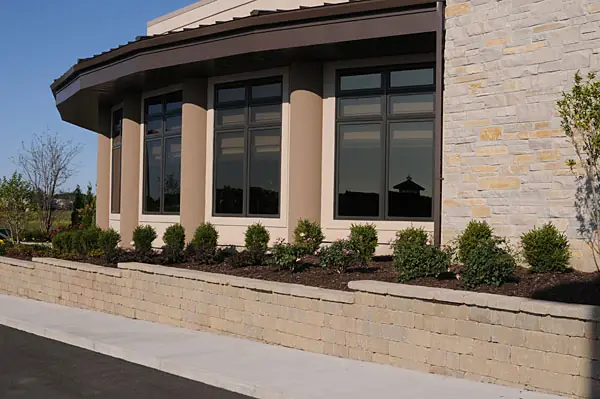 Commercial building stone retaining wall with a planting bed in front of it